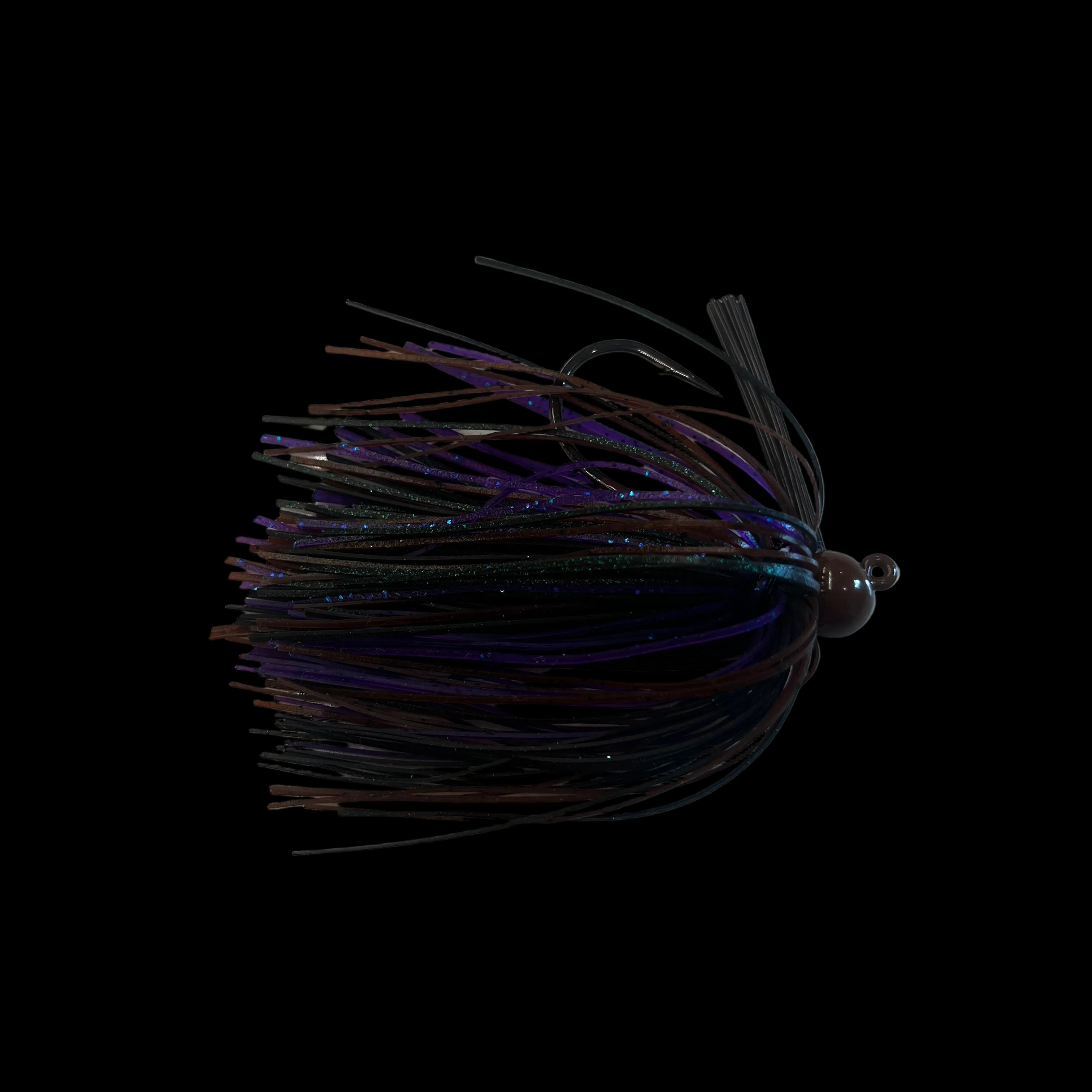 A dark brown and purple skirted fishing lure with black strands, resting on a light gray marble-patterned surface.