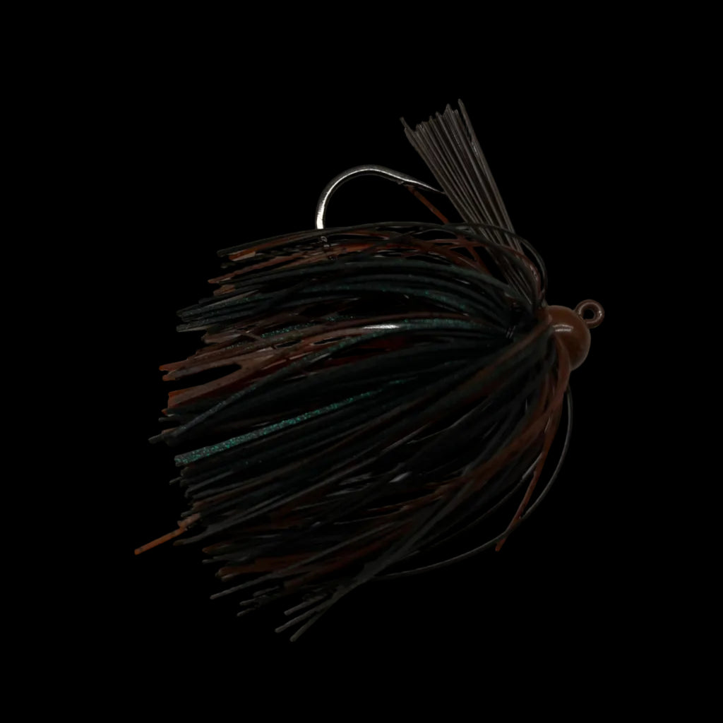 A fishing jig lure with a dark brown and black skirt, a silver metal hook, and a small metal bead head, resting on a light gray marble surface.