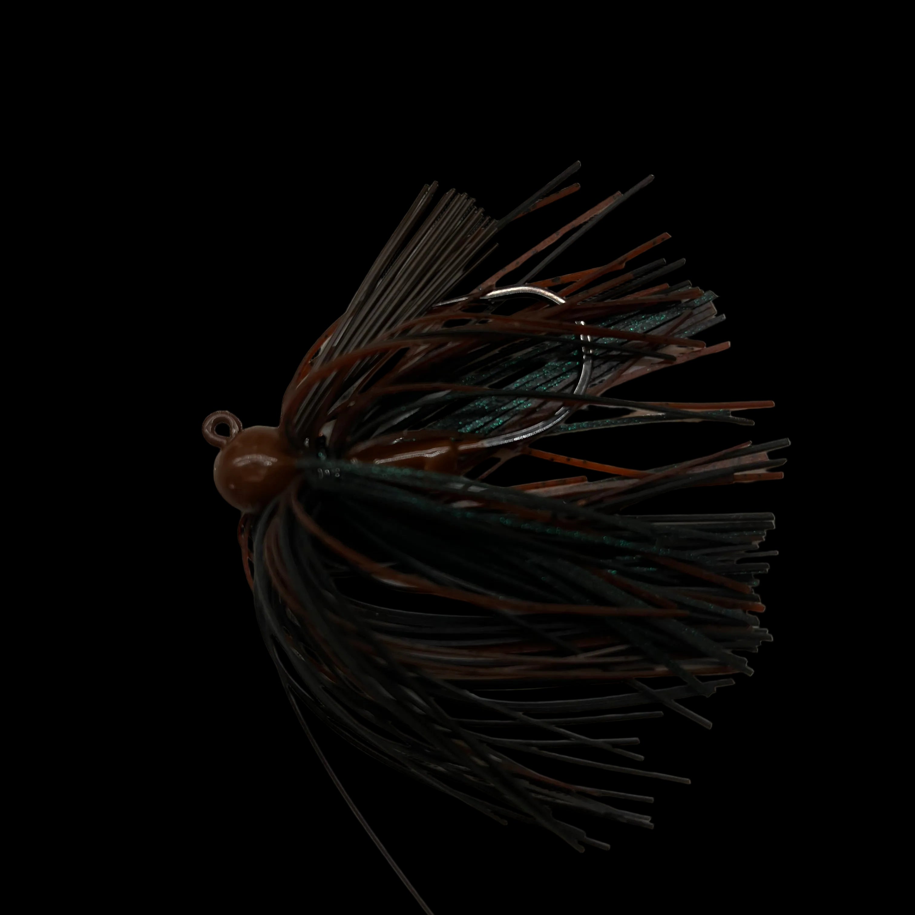 A dark brown and black skirted fishing lure with a small brown bead head, placed on a light beige marble surface.
